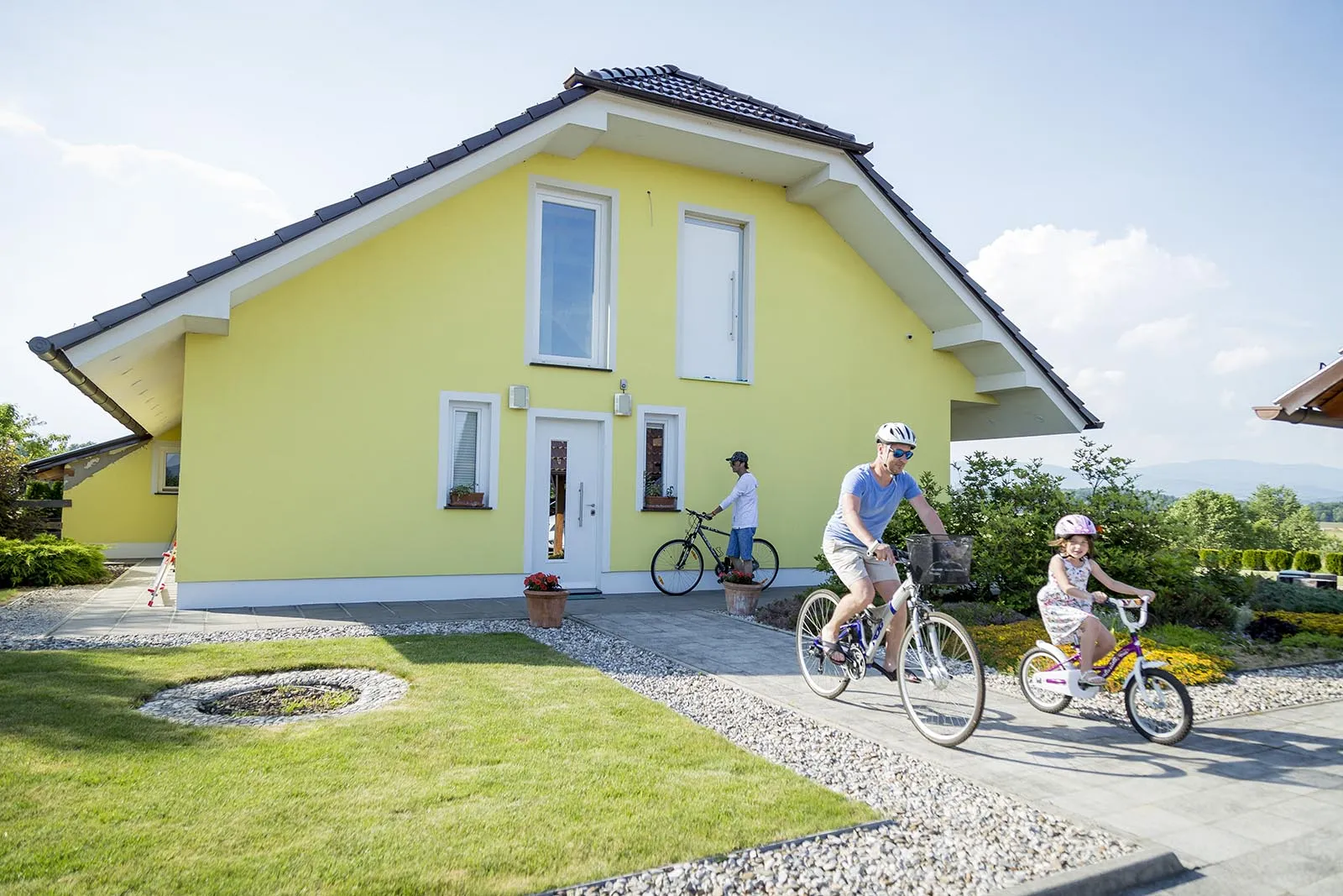 A family cycling in front of Residence Ana